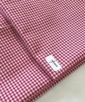 Close-up of folded fuchsia and white 1/8-inch gingham check fabric, showing a crisp, small-scale checkered pattern with a textured weave. Gingham Checked Fabric by Yard 1/8” inch Poly Cotton Checkered Fabric for Tablecloth Dress Curtains, Multiple Colors Available